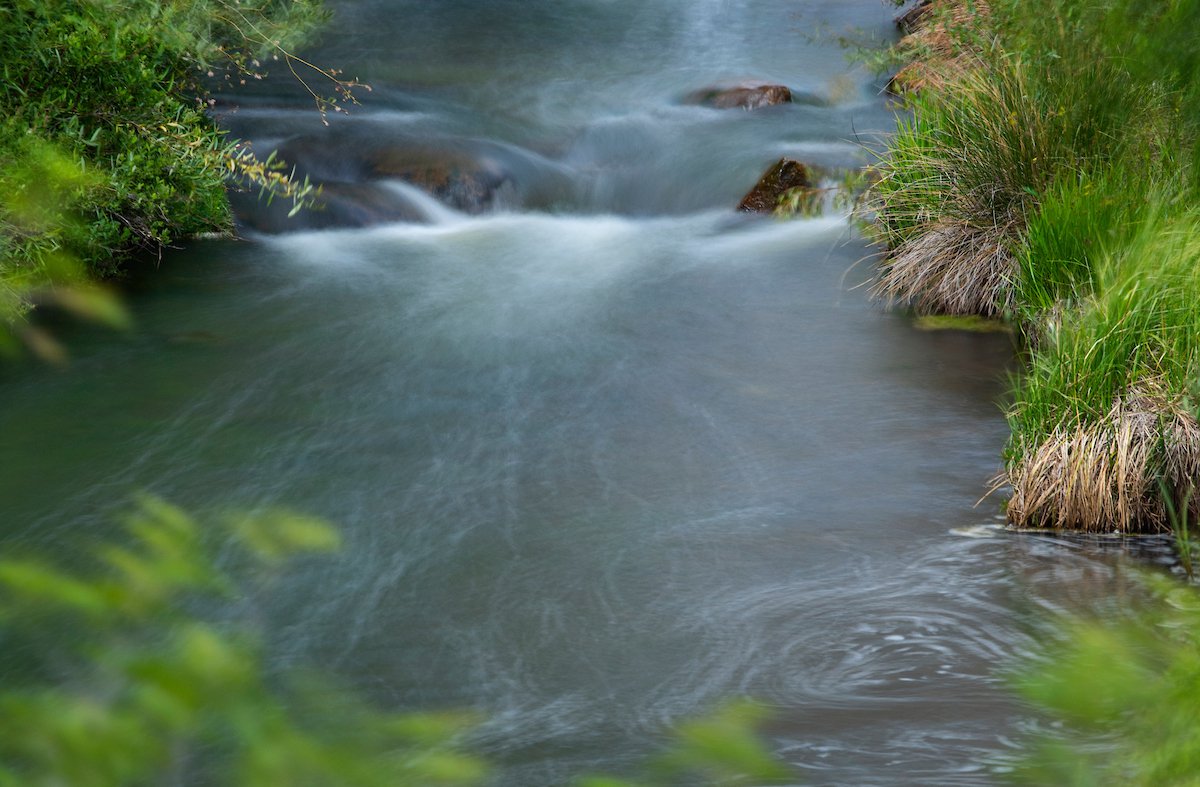 Photo of small stream flowing over rocks.